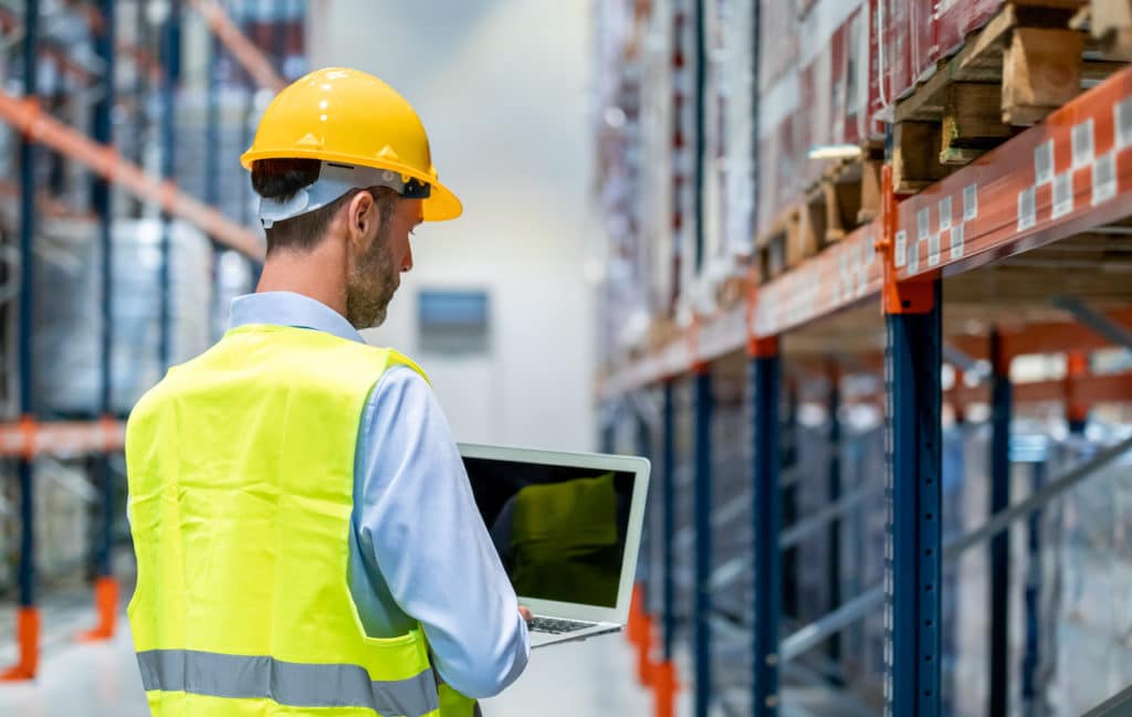 manager using laptop to increase productivity in manufacturing